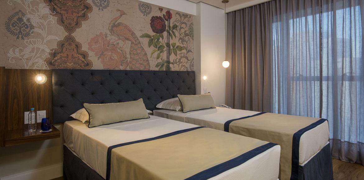 Hotel Luzeiros ريسيفي المظهر الخارجي الصورة The photo shows a modern bedroom featuring two single beds that are neatly made with light-colored blankets and decorative pillows. The headboard of the beds is upholstered in a dark material, giving it a stylish appearance. Behind the beds, there is